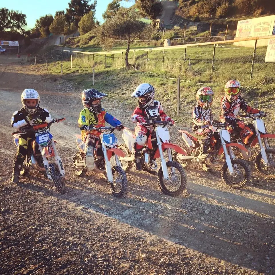 Jeunes pilotes de l'école alignés sur leurs motos au départ, sur la piste