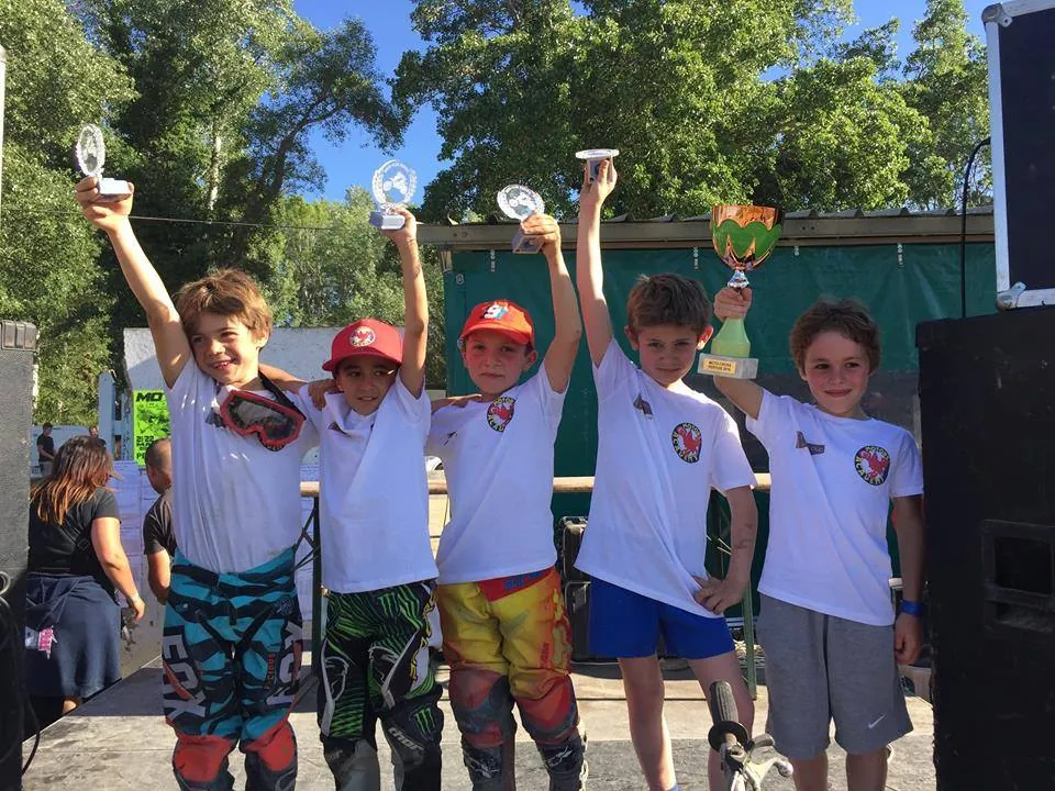 Pilotes de l'école sur le podium, bras levés